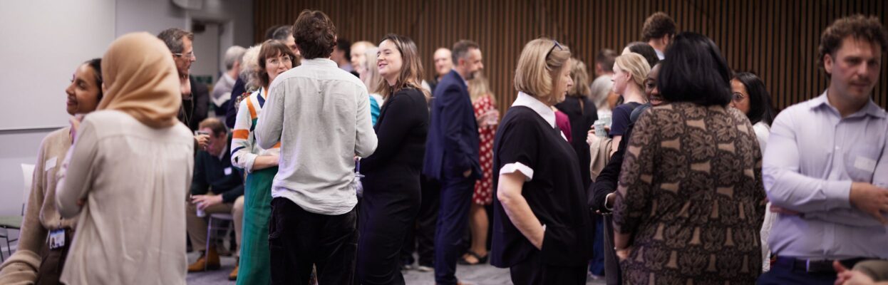 Groups of people are stood around chatting looking engaged at the Ministry of Justice Areas of Research Interest launch.