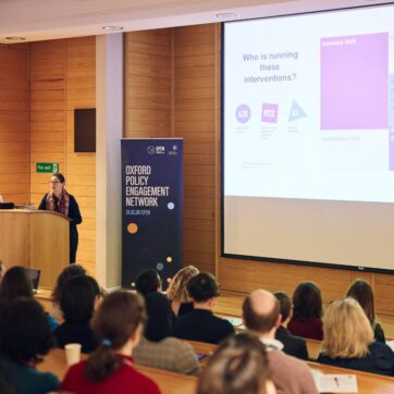 This images shows people listening to a presentation in a lecture theatre.