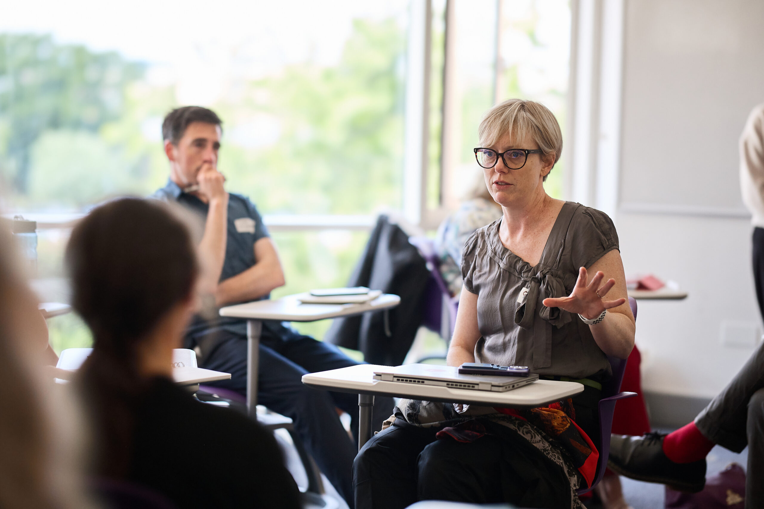 Photo of people sitting at desks in conversation.