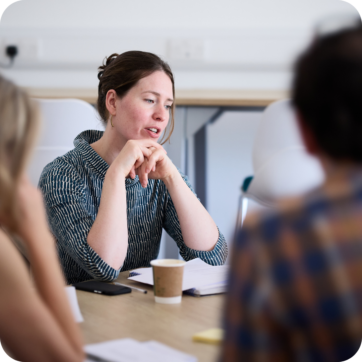 This image focuses on a person sitting around a table.