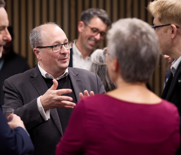 A small group of people talking at a professional event.