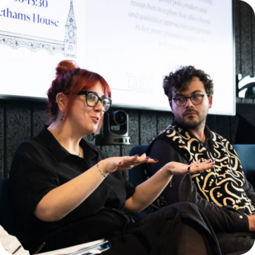 Two people sat presenting at a roundtable.