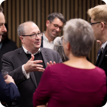 A man stood talking to a group of people.