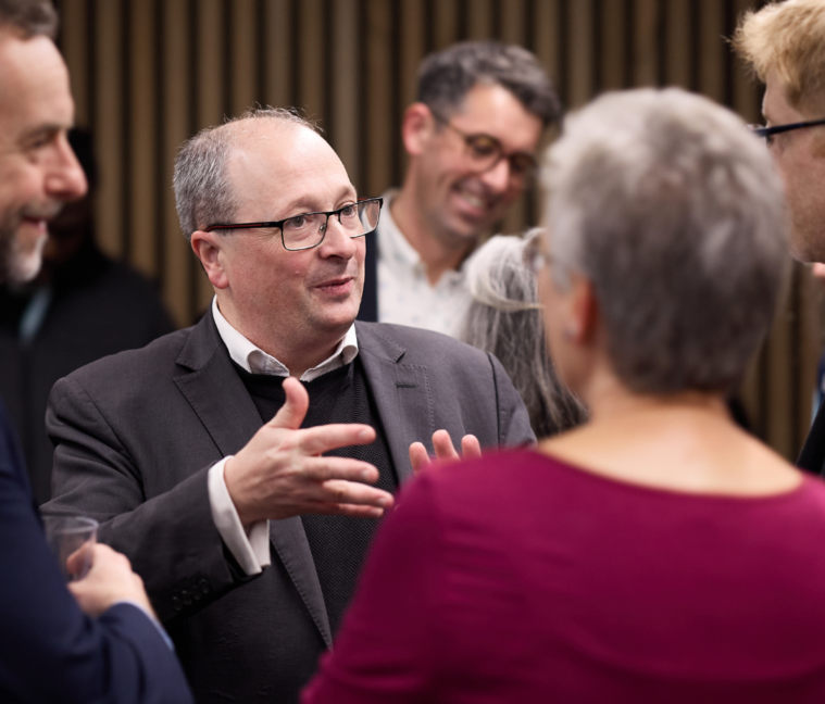 A man stood talking to a group of people.