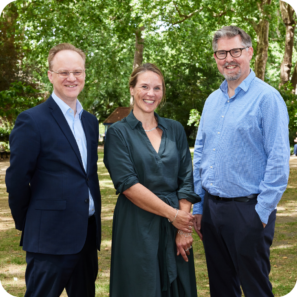UPEN's 3 co-chairs stood smiling in a park.