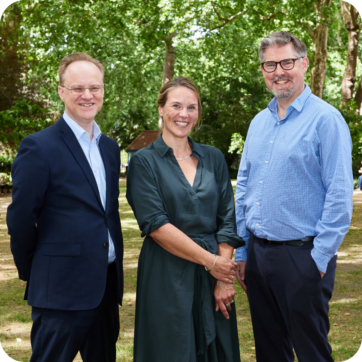 UPEN's 3 co-chairs stood smiling in a park.