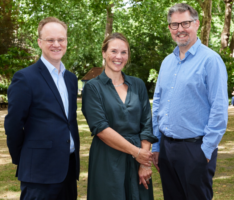 UPEN's 3 co-chairs stood smiling in a park.